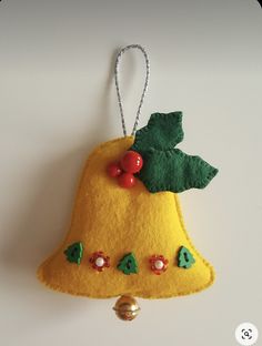 a felt bell ornament with cherries on it