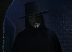 a person wearing a mask and a hat in a dark room with a brick wall