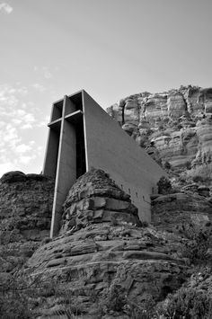 a black and white photo of a building on top of a mountain