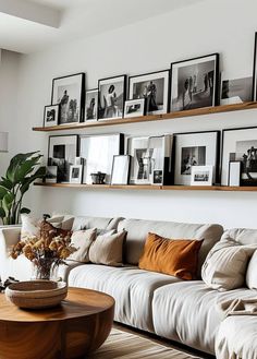 a living room filled with lots of furniture and pictures on the wall above it's coffee table