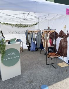 an open tent with clothes on display in front of it and a sign that says ivy grove