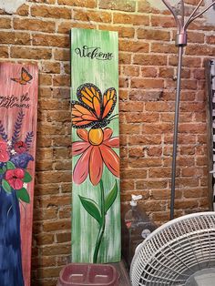 three wooden signs with flowers painted on them next to an air conditioner and fan