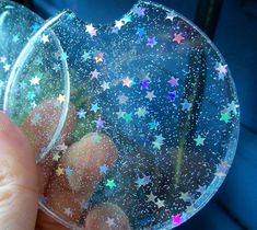 a hand holding a plastic disc with stars on it