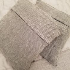 two pillows sitting on top of a bed next to each other