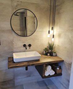 a bathroom with a sink, mirror and plants on the counter in front of it