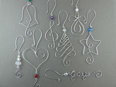 many different types of earrings are hanging on a gray background with the word love spelled out in cursive letters