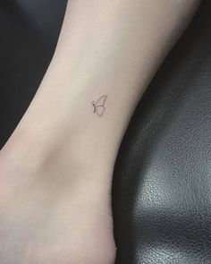 a small butterfly tattoo on the left side of the ankle is shown in black and white