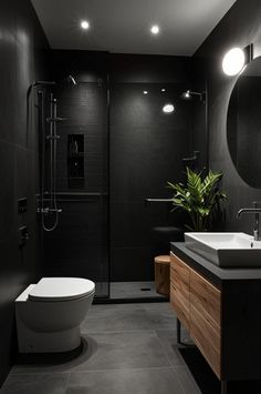 a modern bathroom with black walls and flooring