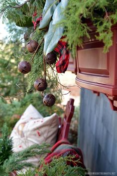 a bunch of bells hanging from the side of a wooden building next to a tree