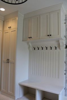 a white bench and some cabinets in a room