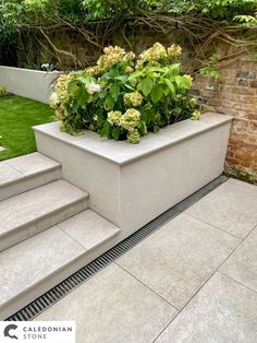 a planter filled with flowers sitting on top of cement steps