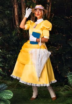 a woman in a yellow dress and hat is posing for the camera with an umbrella