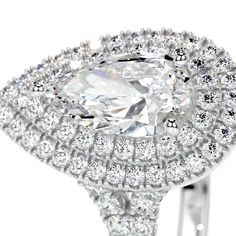 an oval cut diamond surrounded by halos and pave set diamonds in white gold