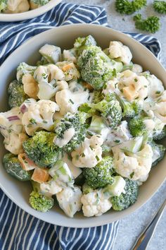 a bowl filled with broccoli and cauliflower on top of a blue towel