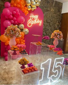 a birthday party with balloons and flowers on display