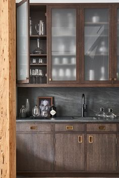 a kitchen with wooden cabinets and black counter tops, along with glass front cupboards