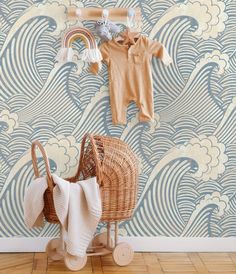 a baby's clothes hanging on the wall next to a wicker stroller