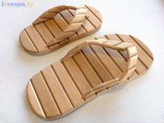 two pairs of wooden sandals sitting on top of a white surface