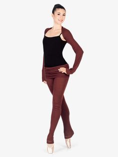 a woman in brown pants and black top posing for the camera with her hands on her hips