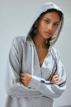 Elevated essential Out From Under X Tommy Hilfiger sweatshirt in a relaxed, slouchy fit. Designed in a super soft fleeced knit featuring a wrap v-neckline, hood with contrast string details and stripes down the sleeves. Find it only at Urban Outfitters. Features Out From Under X Tommy Hilfiger hoodie sweatshirt Lounge pullover sweatshirt Soft & stretchy fleeced knit Wrap v-neckline with hood & string details Stripe details down the sleeves Relaxed, slouchy fit Cropped length Easy pull-over style UO exclusive Content + Care 95% Polyester, 5% spandex Machine wash Imported Size + Fit Model in Navy is 5’7.5" and wearing size Small Measurements taken from size Small Chest: 41" Length: 23.5" | Out From Under,Tommy Hilfiger Out From Under X Tommy Hilfiger Hoodie Sweatshirt in Grey, Women's at Urb Sporty Sweatshirt For Spring Loungewear, Spring Hoodie With Drawstring Hood For Lounging, Sporty French Terry Hoodie For Spring, Sporty Spring Sweatshirt For Loungewear, Hooded Athleisure Tops For Lounging, Sporty Hooded Tops For Leisure, Hooded Relaxed Fit Tops For Loungewear, Relaxed Fit Hooded Top For Loungewear, Hooded Sportswear Tops For Loungewear