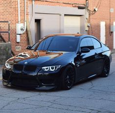 a black car parked in front of a brick building