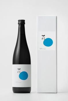 a bottle of wine next to a box on a white surface with a black and blue design