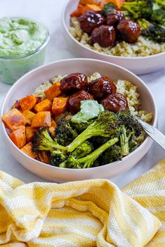 two bowls filled with different types of food on top of a white table next to yellow towels