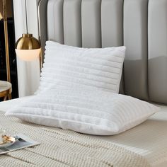 a white pillow sitting on top of a bed