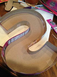 the letter s is cut out of cardboard and placed on top of other crafting supplies