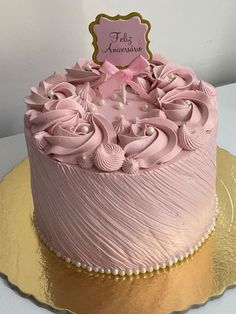 there is a pink cake with flowers on the top and gold plated serving platter