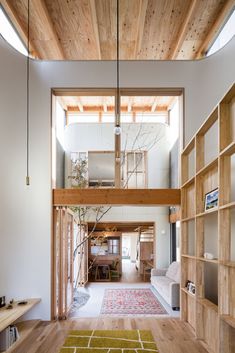 a person sitting on a couch in the middle of a living room with wooden floors