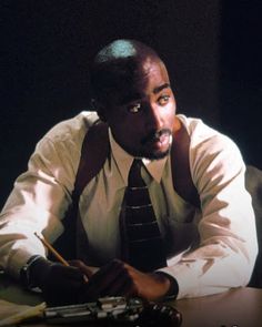 a man sitting at a table with a pen in his hand