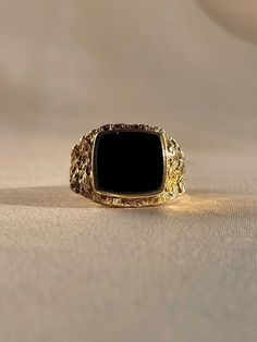 Vintage 9k yellow gold onyx signet ring from the United Kingdom, featuring beautiful hammered textured shoulders. Excellent vintage condition Size: 9.5 Weight: 8.2 grams Band: 15.5 mm (front), 2.8 mm (back) Onyx: 11.7 mm x 12.8 mm Hallmarks: 9 for 9k Please note, vintage and antique jewelry may come with imperfections commensurate of their age. To see more photos and videos of this piece, visit our Instagram: www.instagram.com/23carat PLEASE READ ALL POLICIES regarding shipping, returns, tax, et Vintage Tarnish Resistant Signet Ring For Formal Occasions, Timeless Gold Signet Ring With Black Enamel, Vintage Gold Signet Ring With Black Enamel, Formal Gold Onyx Signet Ring, Formal Gold Signet Ring With Onyx, Gold Onyx Signet Ring For Formal Occasions, Luxury Black Signet Ring Tarnish Resistant, Elegant Gold Signet Ring With Black Enamel, Antique Tarnish-resistant Rings For Formal Occasions