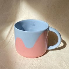 a pink and blue cup sitting on top of a table