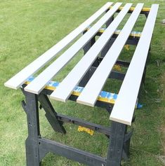 a picnic table that is sitting in the grass with blue tape around it's edges