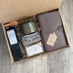 an open box with items inside on a wooden table next to a cup and saucer