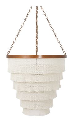 a chandelier hanging from a chain with white fabric and wood trimmings