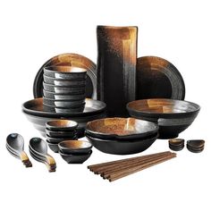 an assortment of black and gold dinnerware