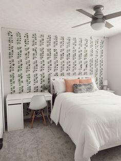 a bedroom with a bed, desk and ceiling fan