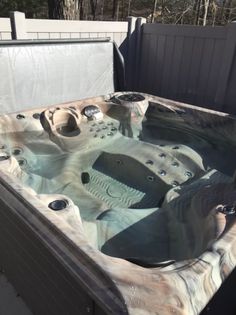 an outdoor hot tub in the middle of a yard