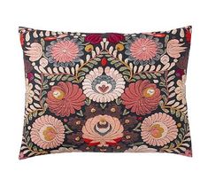 an embroidered pillow with flowers and leaves on the front, in black and pink colors