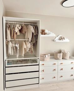 a baby's closet with clothes hanging on the rails