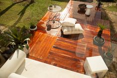 a wooden deck with white furniture and plants