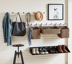 there is a coat rack with baskets and shoes on the wall next to a stool