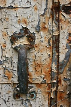 an old rusted door with a rusty handle