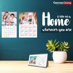 a desk with a calendar, potted plant and photos on the wall next to it