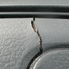 the corner of a car door that is covered in snow and has some rust on it