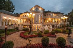 a large house with lots of windows and lights on it's front lawn area