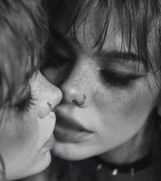 two women kissing each other with their noses close together