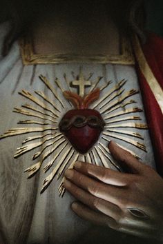 the heart is surrounded by gold nails and a cross on it's chest,